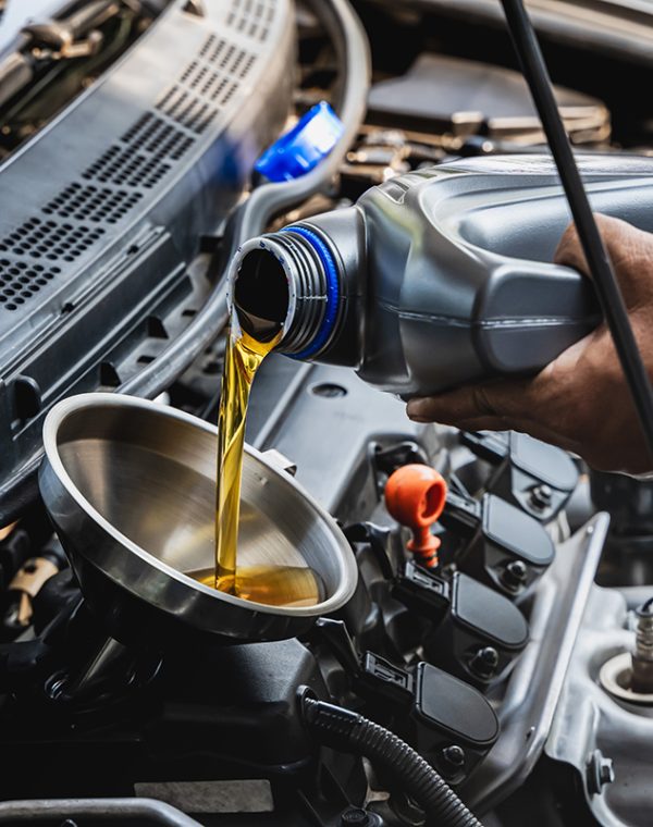 Car,Mechanic,Pouring,Engine,Oil,Into,Vehicle,During,Doing,Car Car mechanic pouring engine oil into vehicle during doing car maintenance in garage