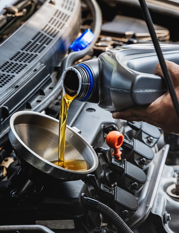 Car,Mechanic,Pouring,Engine,Oil,Into,Vehicle,During,Doing,Car Car mechanic pouring engine oil into vehicle during doing car maintenance in garage